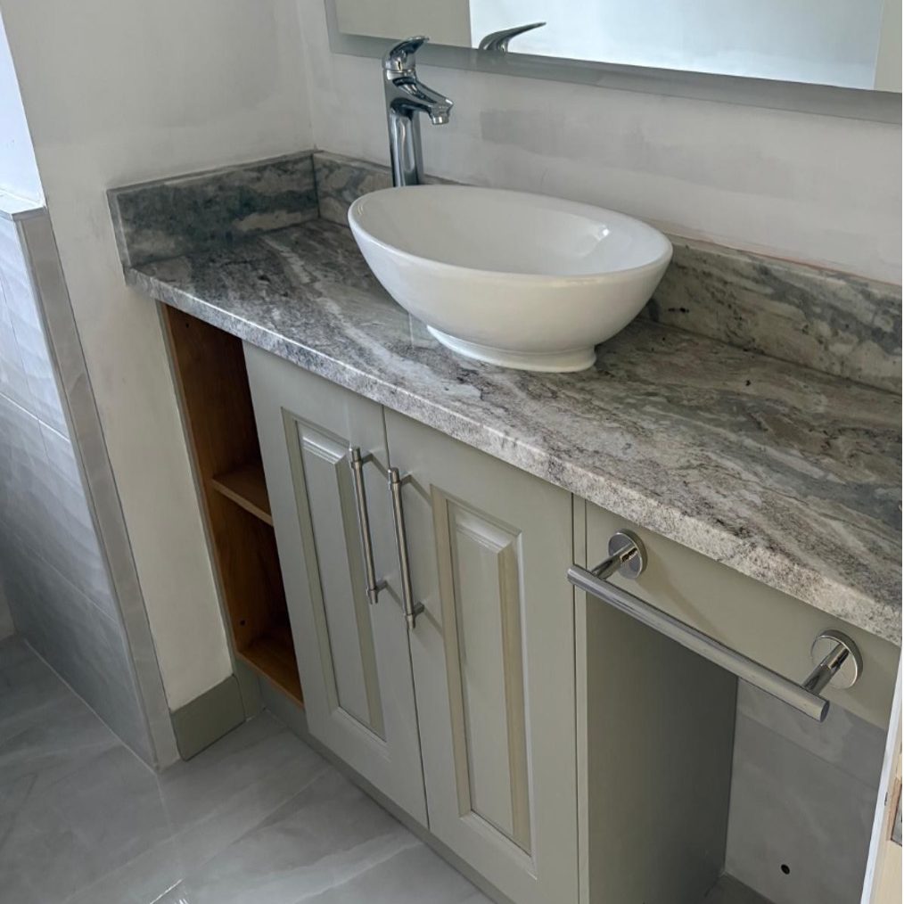 Finished cloakroom vanity with chrome mixer tap, mirror, tiled walls and floor by AGG Renovations